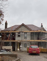 a house under construction with a car in front of it